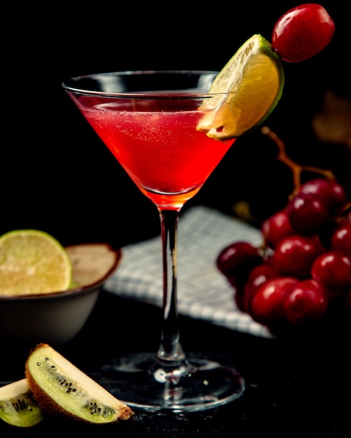 Red cocktail on the table with lemon slice