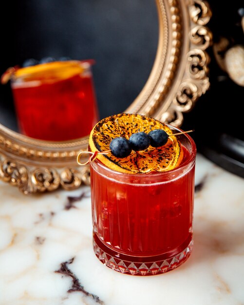 Red cocktail with lemon and berries