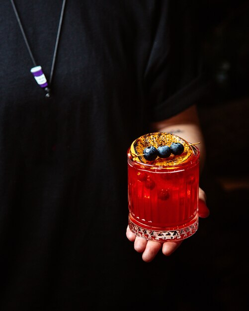 Red cocktail with lemon and berries