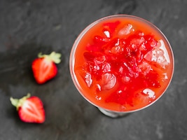 Red cold cocktail with ice and fresh strawberry