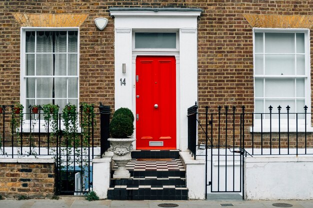 Red colored front door of a city house