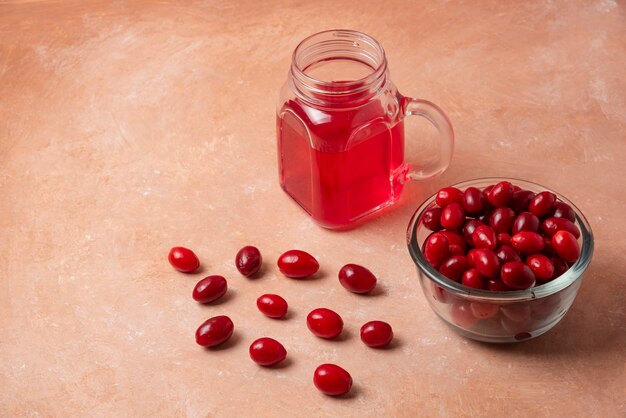 Red cornels in glass cup with juice in the jar. 