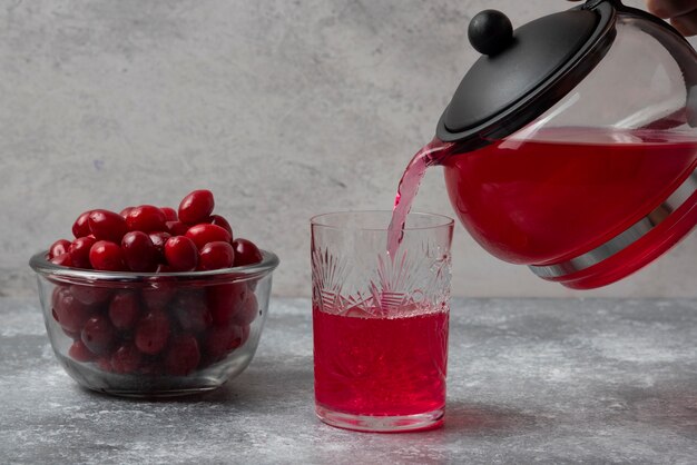 Red cornels with a kettle and glass of juice.