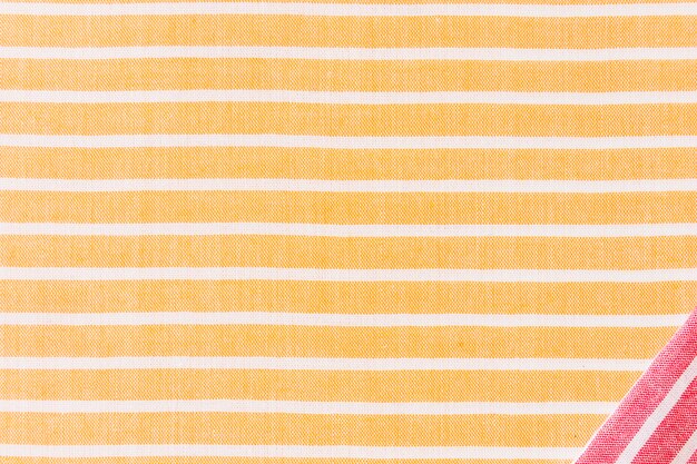 Red corner fabric on yellow and white stripes textile backdrop