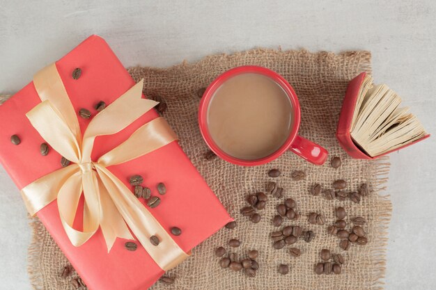 Red cup, book and coffee beans with gift box