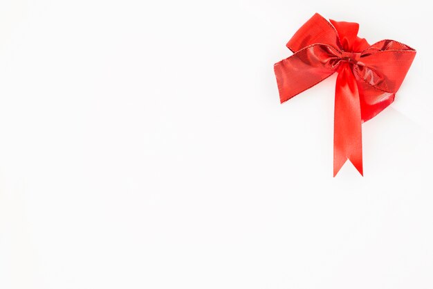 Red decorative bow on the corner of white background