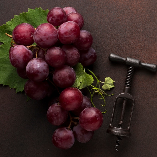 Free photo red delicious grapes and corkscrew