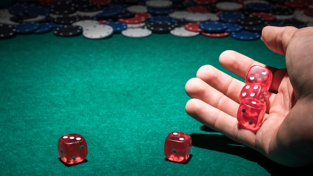 Red dice on human hand in casino