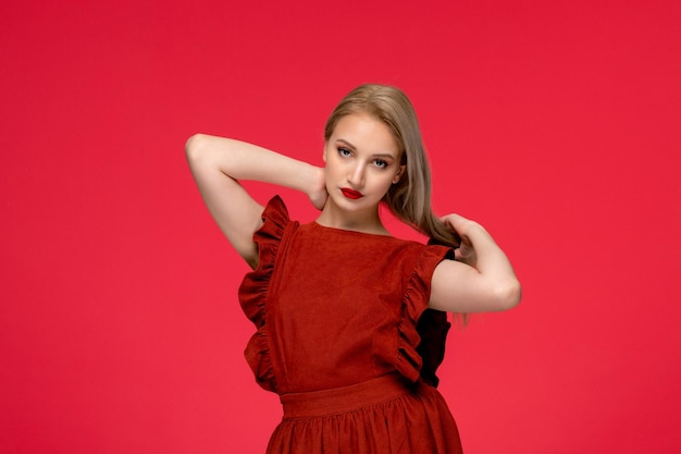 Free photo red dress adorable cute blonde woman wearing burgundy dress with lipstick touching hair