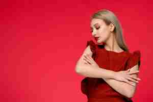 Free photo red dress cute classy adorable girl in burgundy dress with red lipstick gently embracing herself