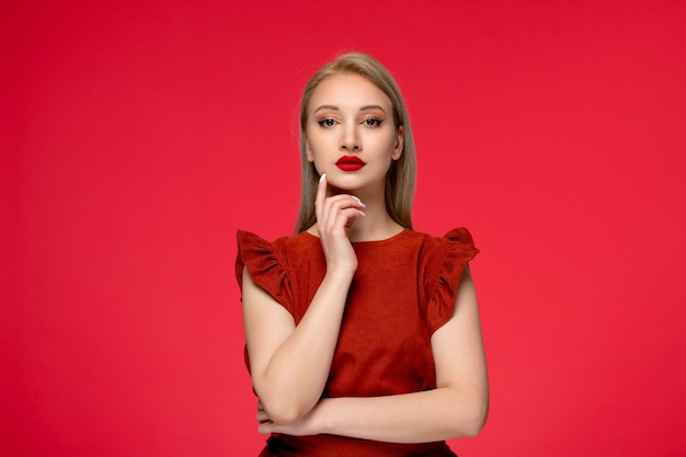 Free photo red dress cute classy adorable girl in burgundy dress with red lipstick holding finger on chin