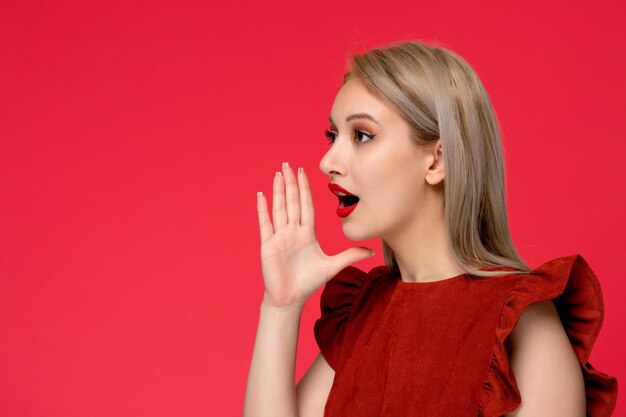 Red dress cute classy elegant girl in burgundy dress with red lipstick hands around mouth calling