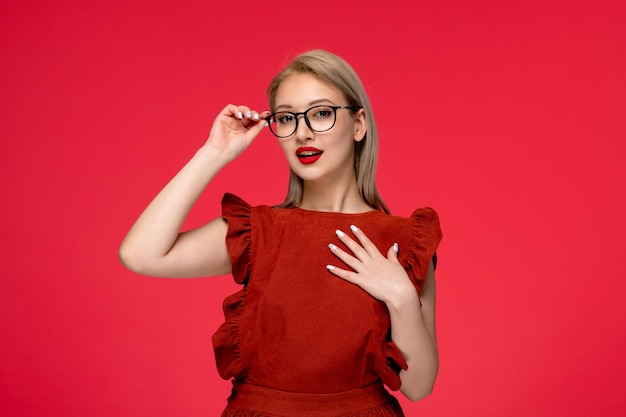 Vestito rosso ragazza carina elegante di classe in abito bordeaux con rossetto rosso che tocca l'angolo degli occhiali