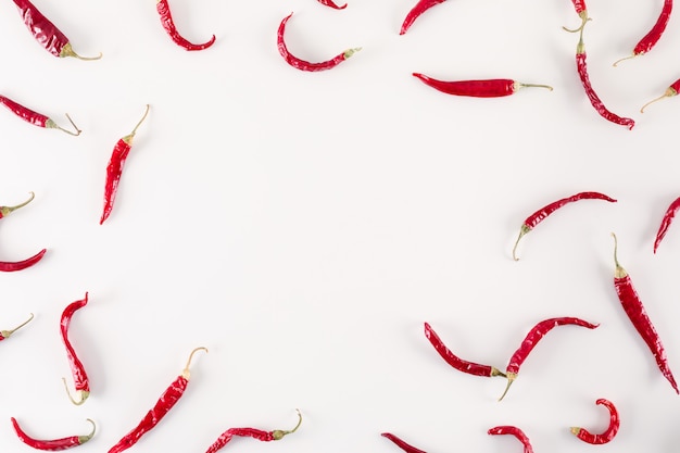 red dried chili peppers top view with copy space on white surface