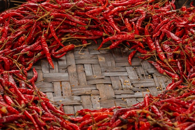 Red dried chilies placed on the space on the weave.