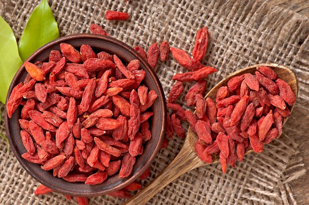 Red dried goji berries in wooden spoon