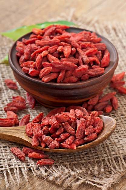 Red dried goji berries in wooden spoon