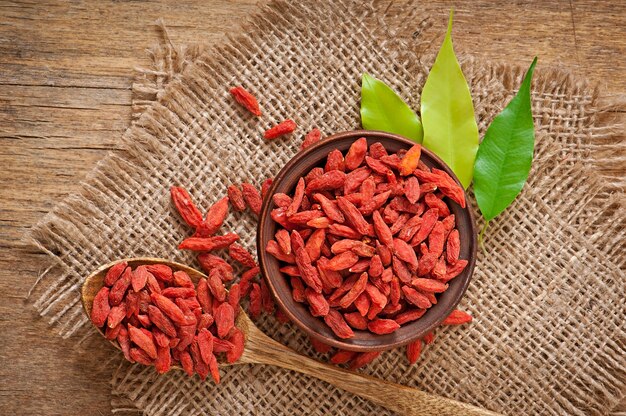 Red dried goji berries in wooden spoon