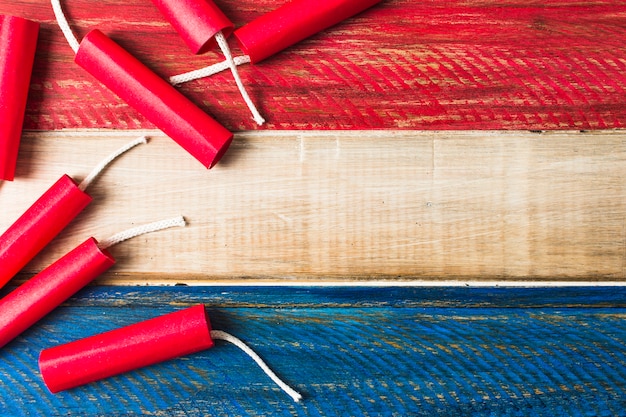 Red dynamite firecrackers on wooden painted wooden plank background