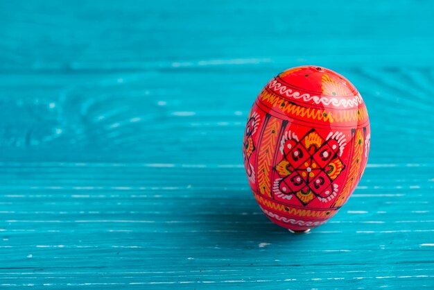 Red easter egg on blue wooden surface