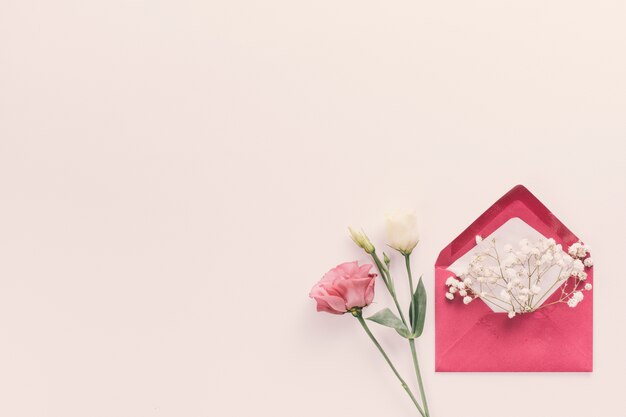 Red envelope with flower branches on table