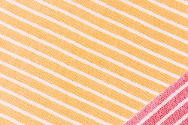 Tessuto rosso sulla tovaglia tessile a strisce gialle e bianche
