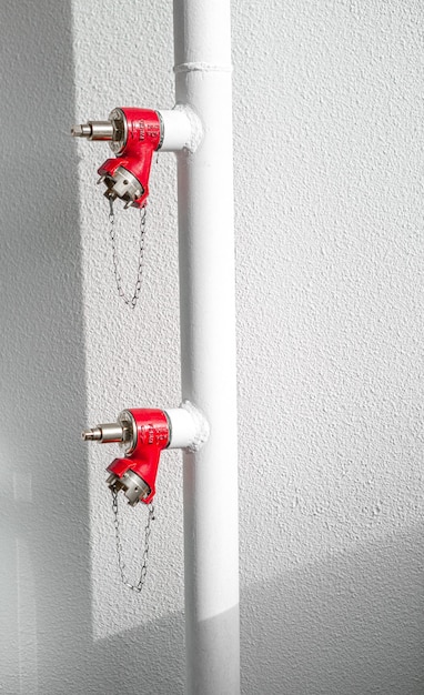 Red fire extinguisher on white wall