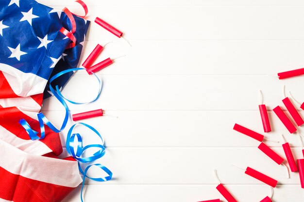 Red firecrackers and blue ribbons with american usa flag on white table