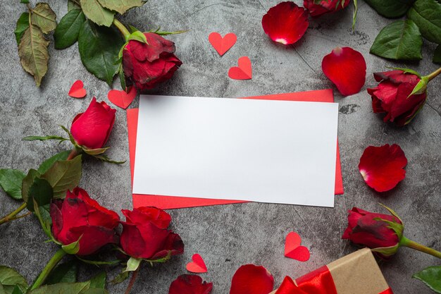 Red flowers of rose and envelop on dark background