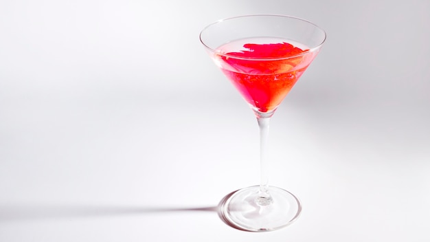 Red food color diffuse inside the martini glass isolated on white background