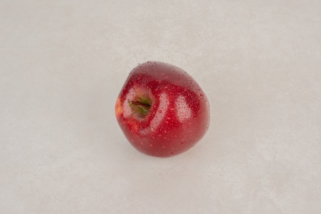 Красное свежее яблоко на белом фоне.