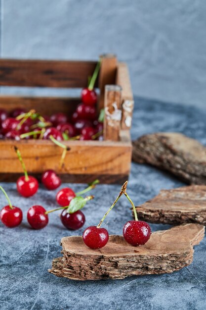 Red fresh juicy cherries in a wooden box with leaves