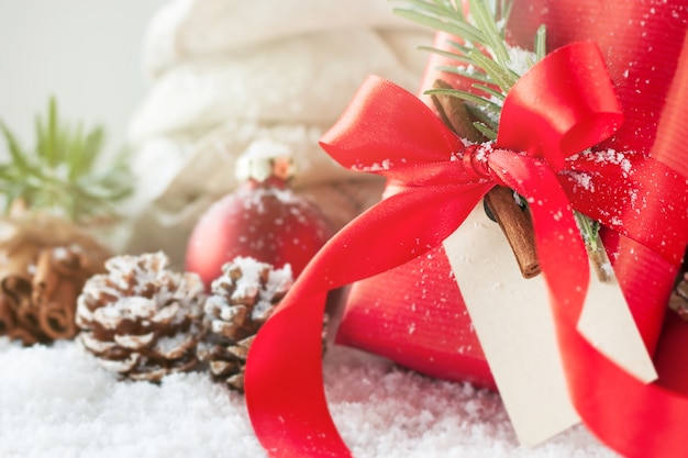 Red gift with red bow and pine cones