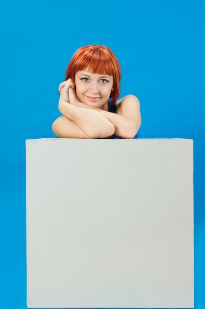 Red girl with blank board over blue background