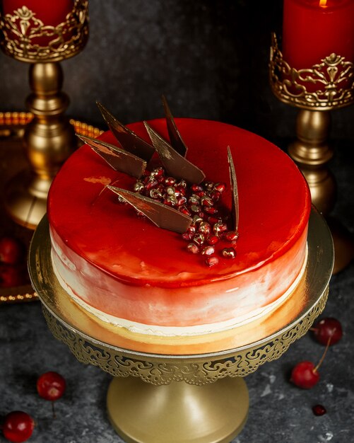 Red glazed cake with pomegranate and caramel triangles
