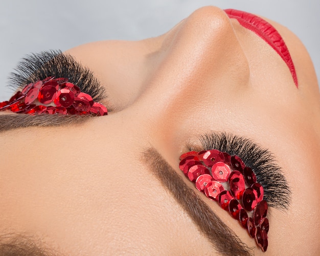 Free photo red glitter eye shadow on proffesional model