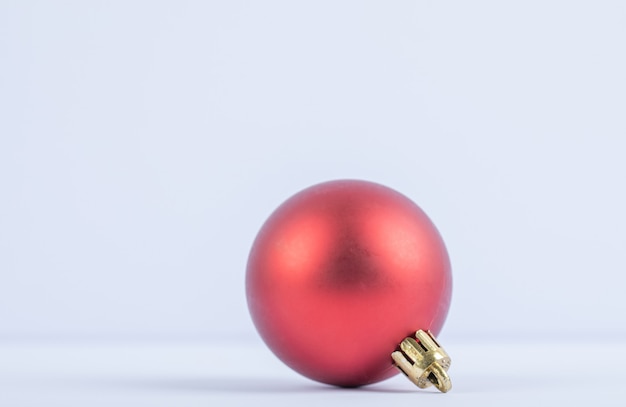 A red glittering or shining oak tree ball on a white