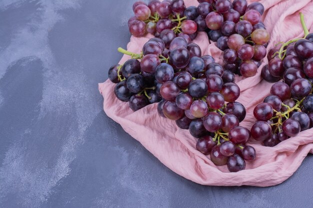 Red grape bunches on piece of pink towel.