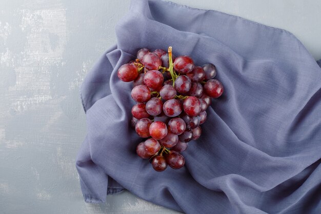 Red grapes on textile and plaster,