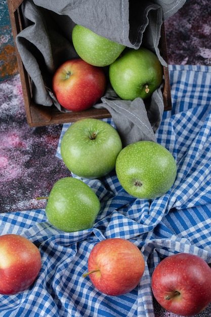 Free photo red and green apples on checked towel.