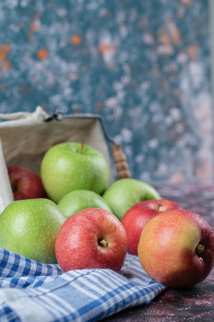 Red and green apples isolated on blue checked towel.