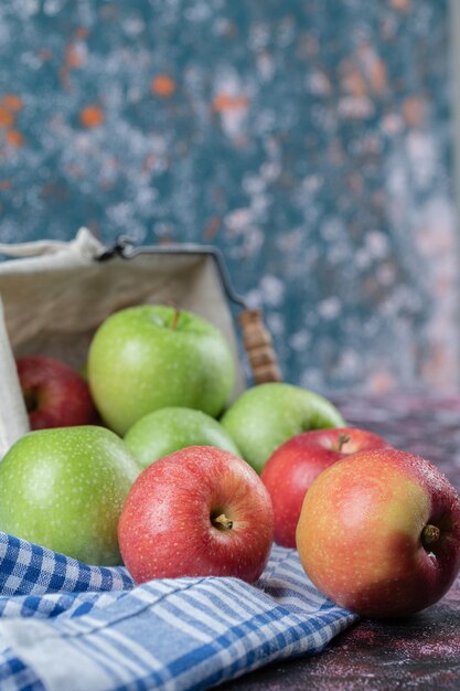 Red and green apples isolated on blue checked towel.