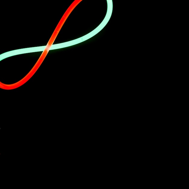 Red and green neon bow design on the corner of black background