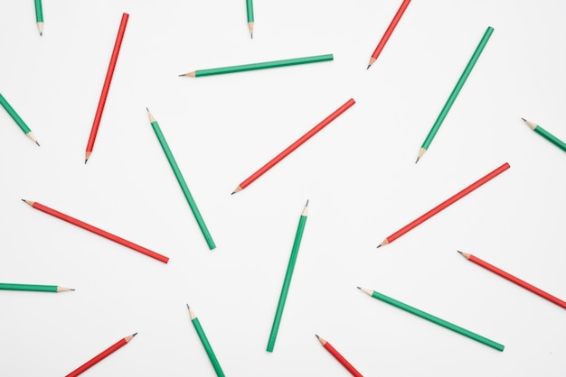 Red and green pencils on white backdrop