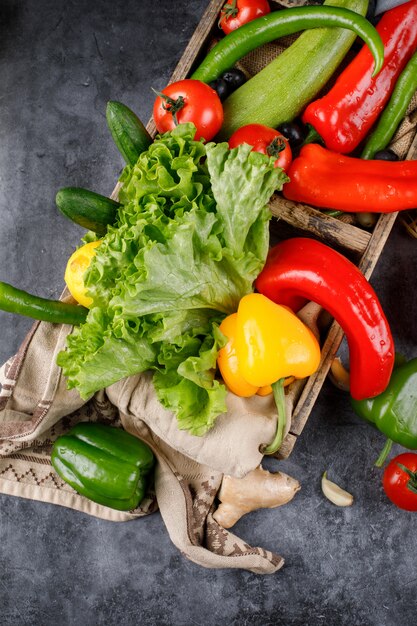 Red, green, yellow chilies with a bunch of lettuce.