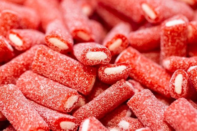 Red gummies covered with sugar candy background