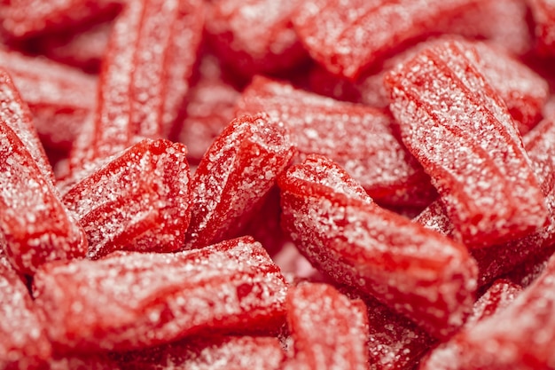 Red gummies jelly candies in sugar background