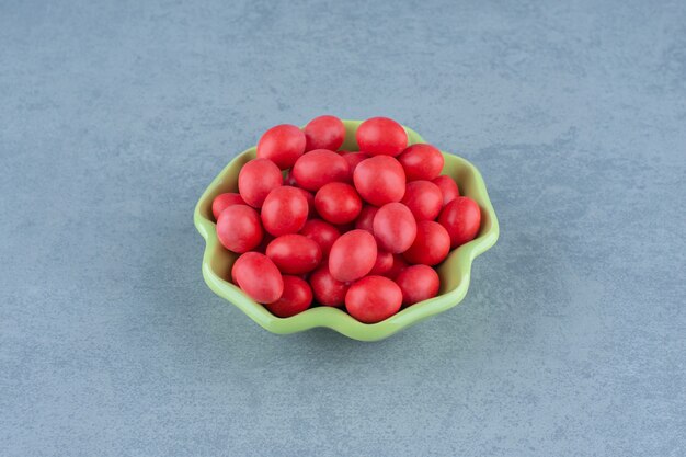 Red gums in the bowl, on the marble table. 