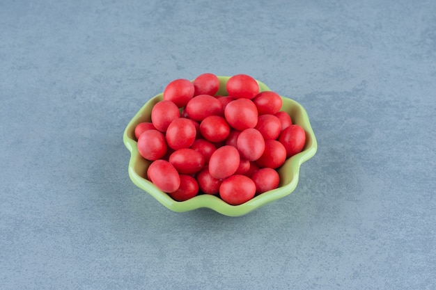 Red gums in the bowl, on the marble table. 