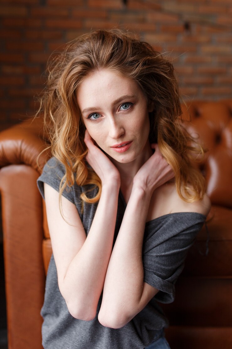 Free Photo red hair woman portrait. brick loft wall on background. serie
